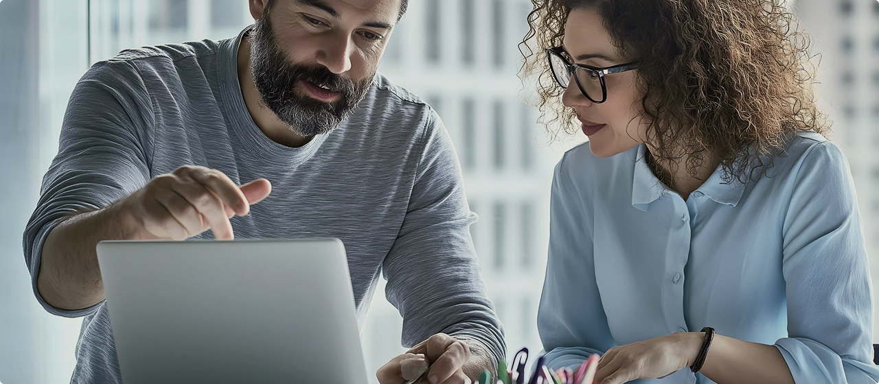 Two people collaborating over a laptop.